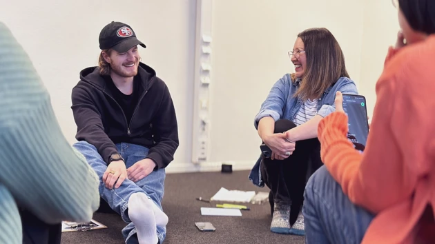 A teacher and a student sitting on the floor.