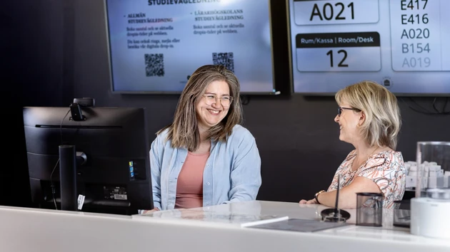 Två leende servicemedarbetare står redo i Infocenter att ta emot frågor. 