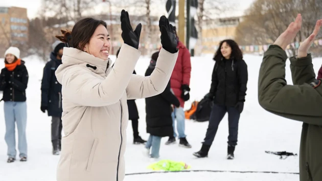 A student has her hands raised to do a double high five.