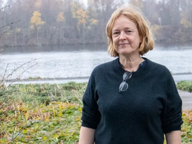 Lecturer Tonia Carless infront of Umeå river in autumn